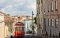 Historic classic red tram of Lisboa built partially of wood navigating, narrow, winding streets